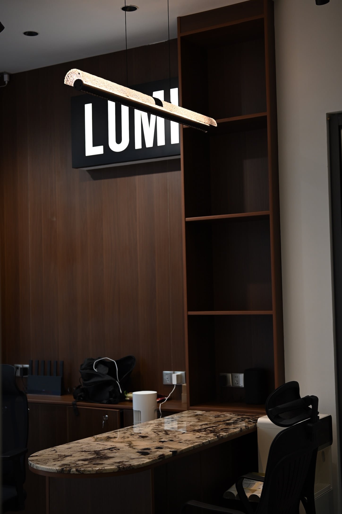LUMI showroom reception with illuminated brand sign